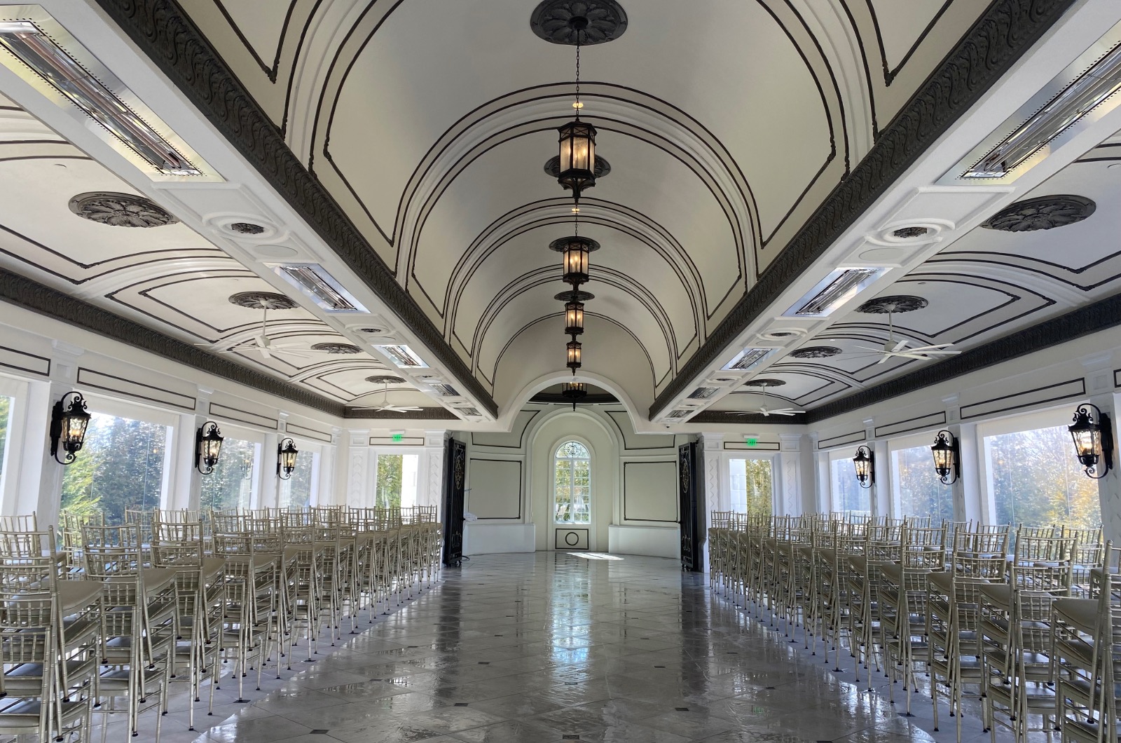 The indoor wedding chapel at Shadowbrook at Shrewsbury with floor-to-ceiling windows overlooking the gardens.