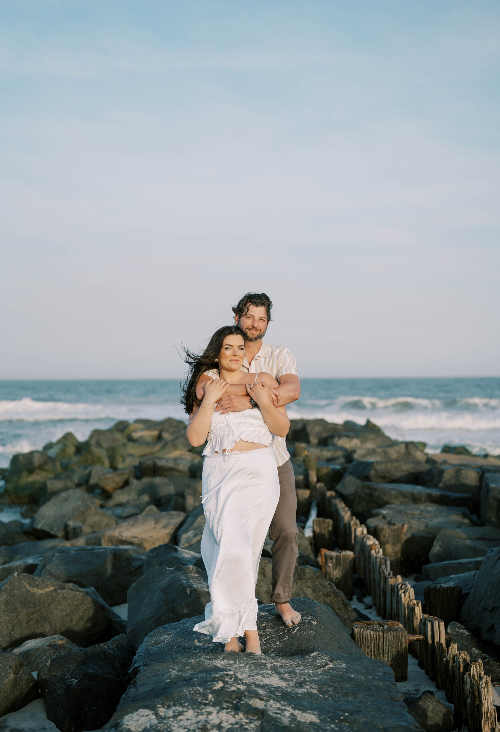Bride and groom taking engagement photos on the beach in Long Beach Island NJ.