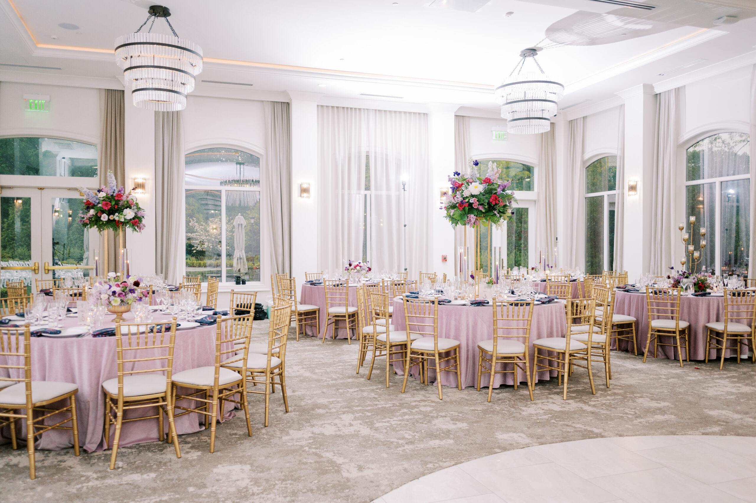 The reception featuring pink tablecloths and centerpieces with flowers of various shades of pink at this Chateau Grande Hotel wedding.