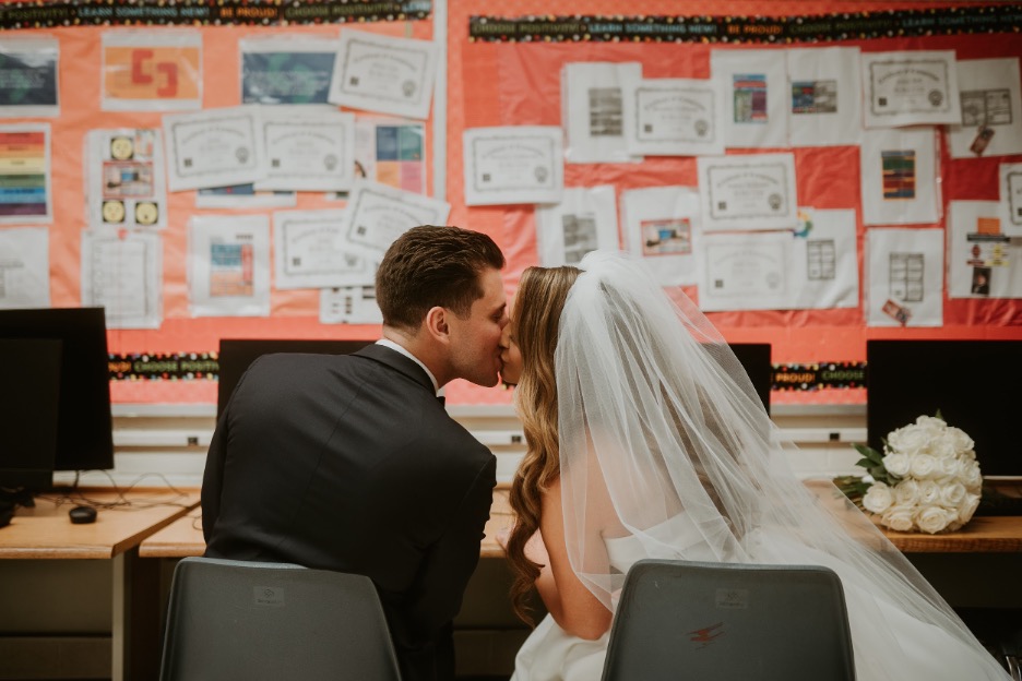 The bride and groom make a pitstop at their high school, where they met, on their wedding day.