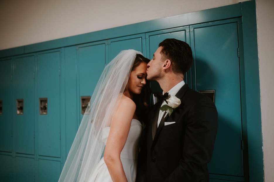 The bride and groom make a pitstop at their high school, where they met, on their wedding day.