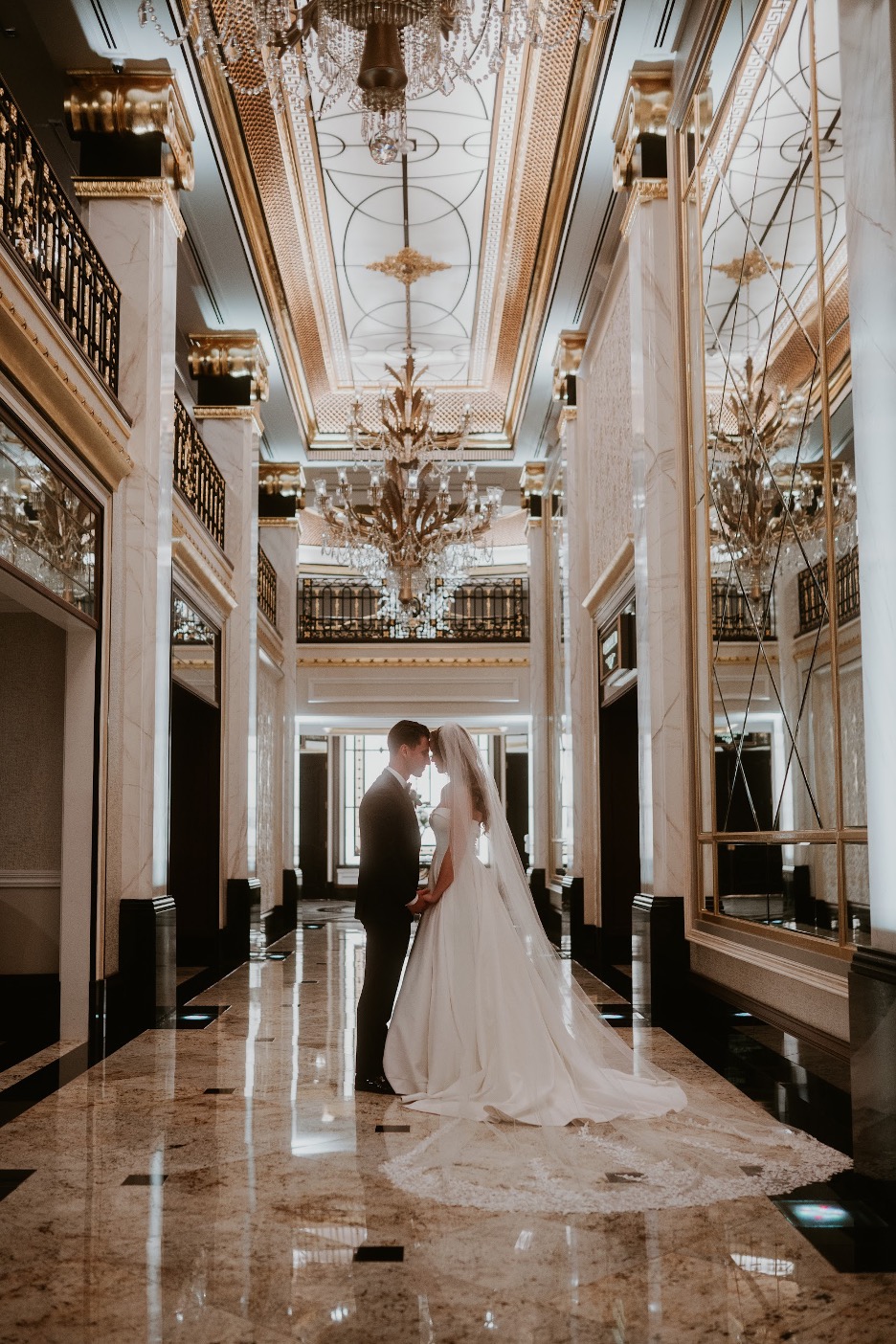 The bride and groom pose in the elaborate entryway at their Shadowbrook at Shrewsbury wedding.