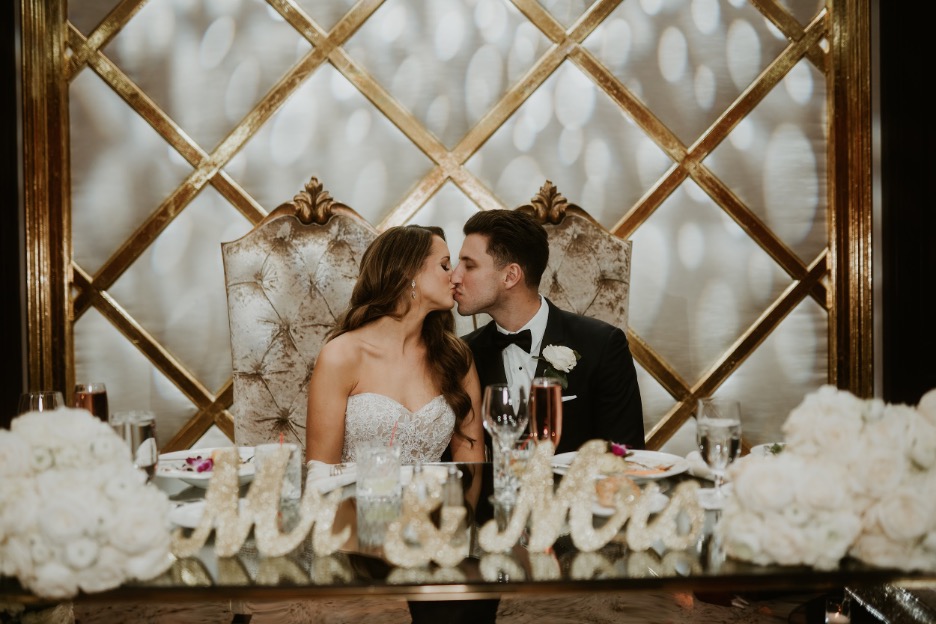The bride and groom kiss at their sweetheart table at their Shadowbrook at Shrewsbury wedding.