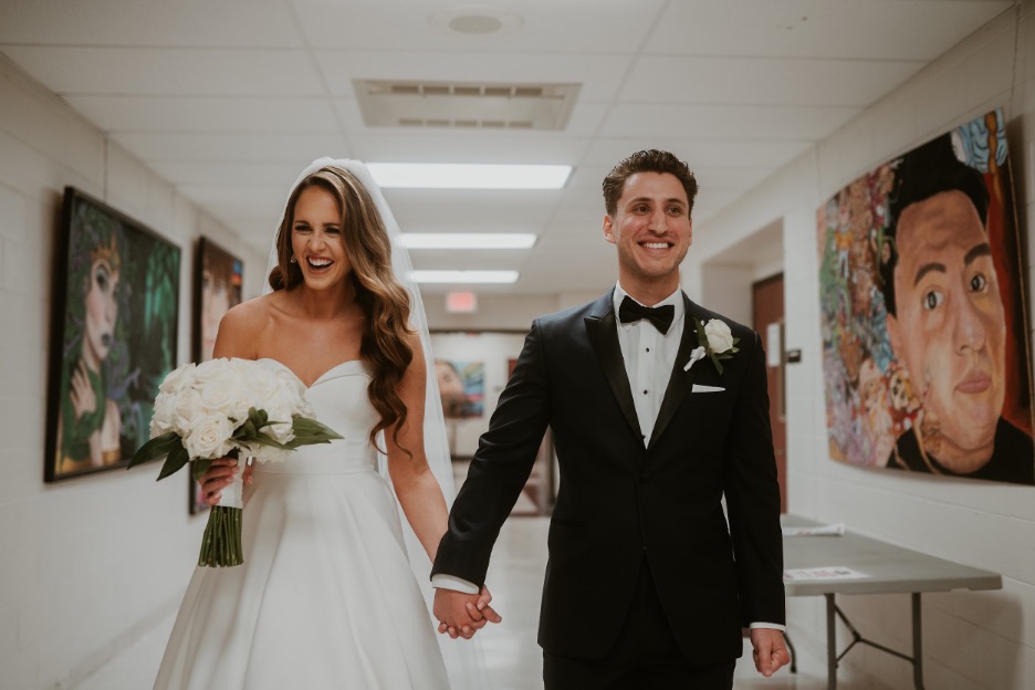 The bride and groom make a pitstop at their high school, where they met, on their wedding day.