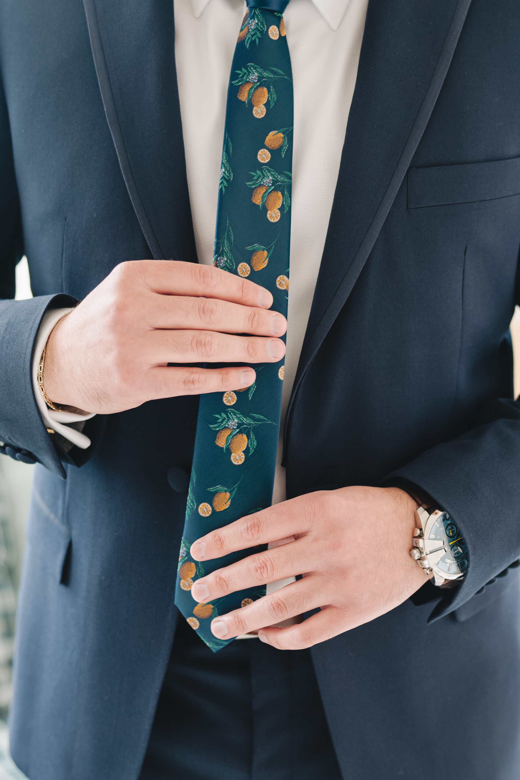 The groom adjusts his fun citrus themed tie ahead of his Porta Asbury Park wedding.