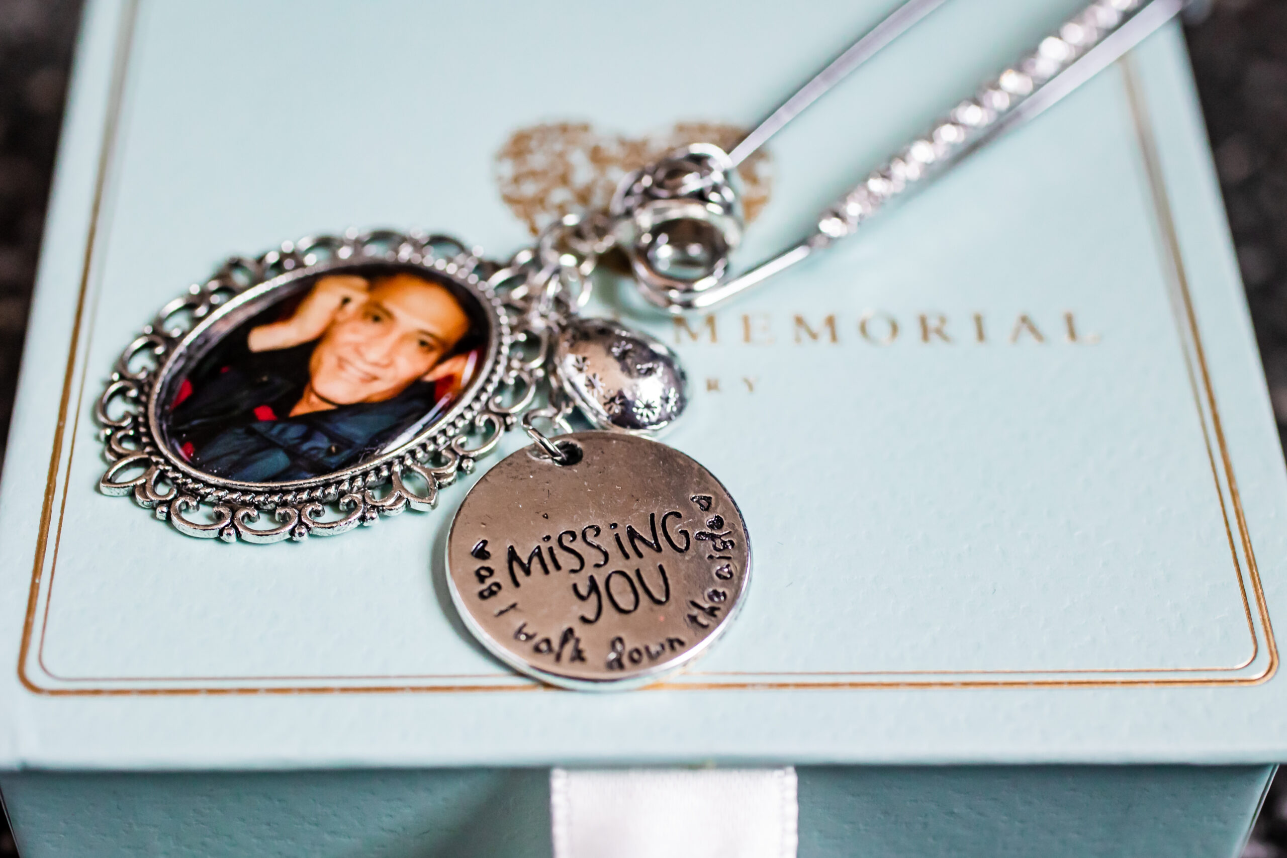 A charm with a photo of her father that will hang on the bride's bouquet at her Palace at Somerset Park wedding.