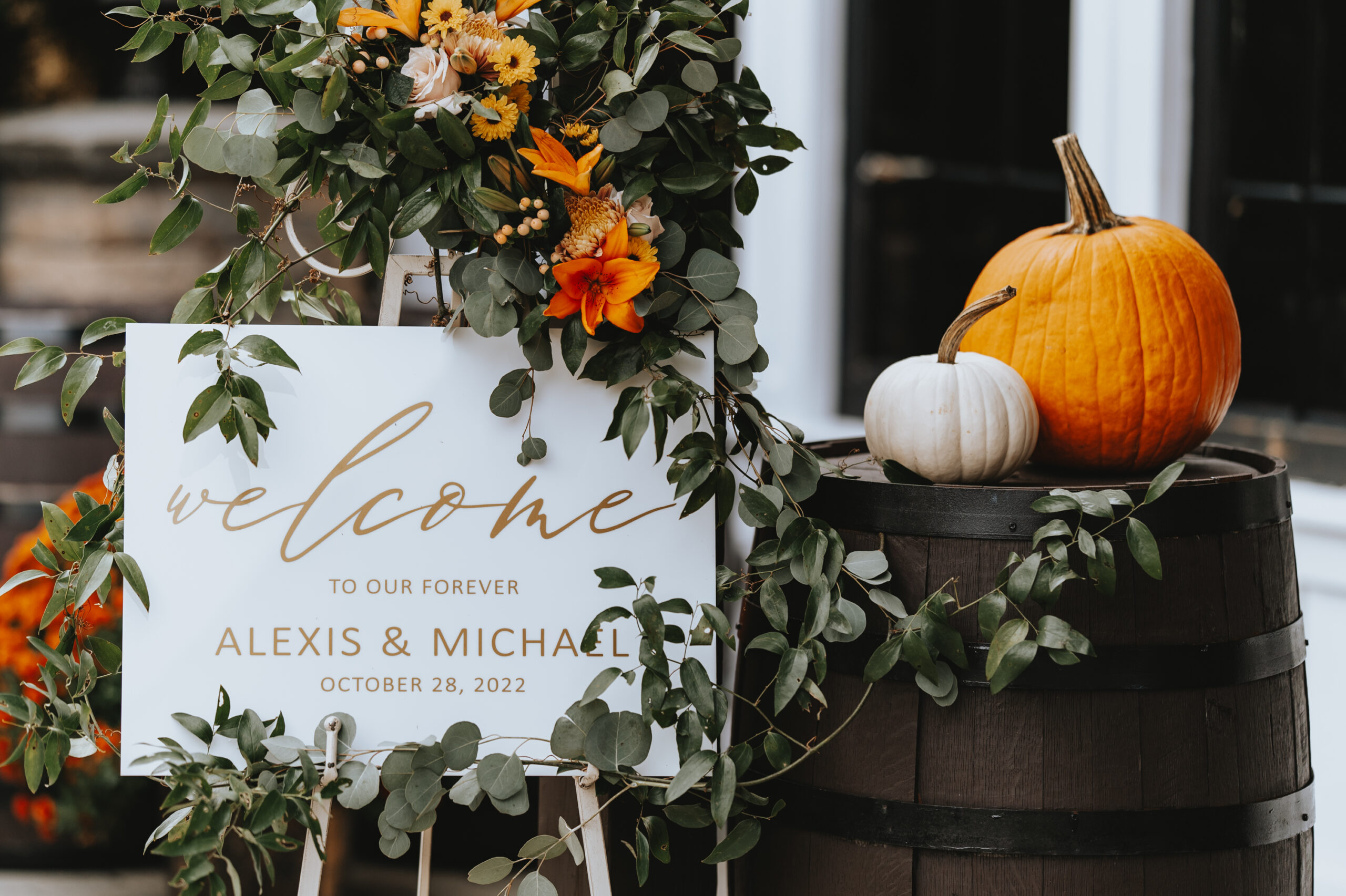 The welcome sign table features pumpkins for this fall-themed Hamilton Manor wedding.