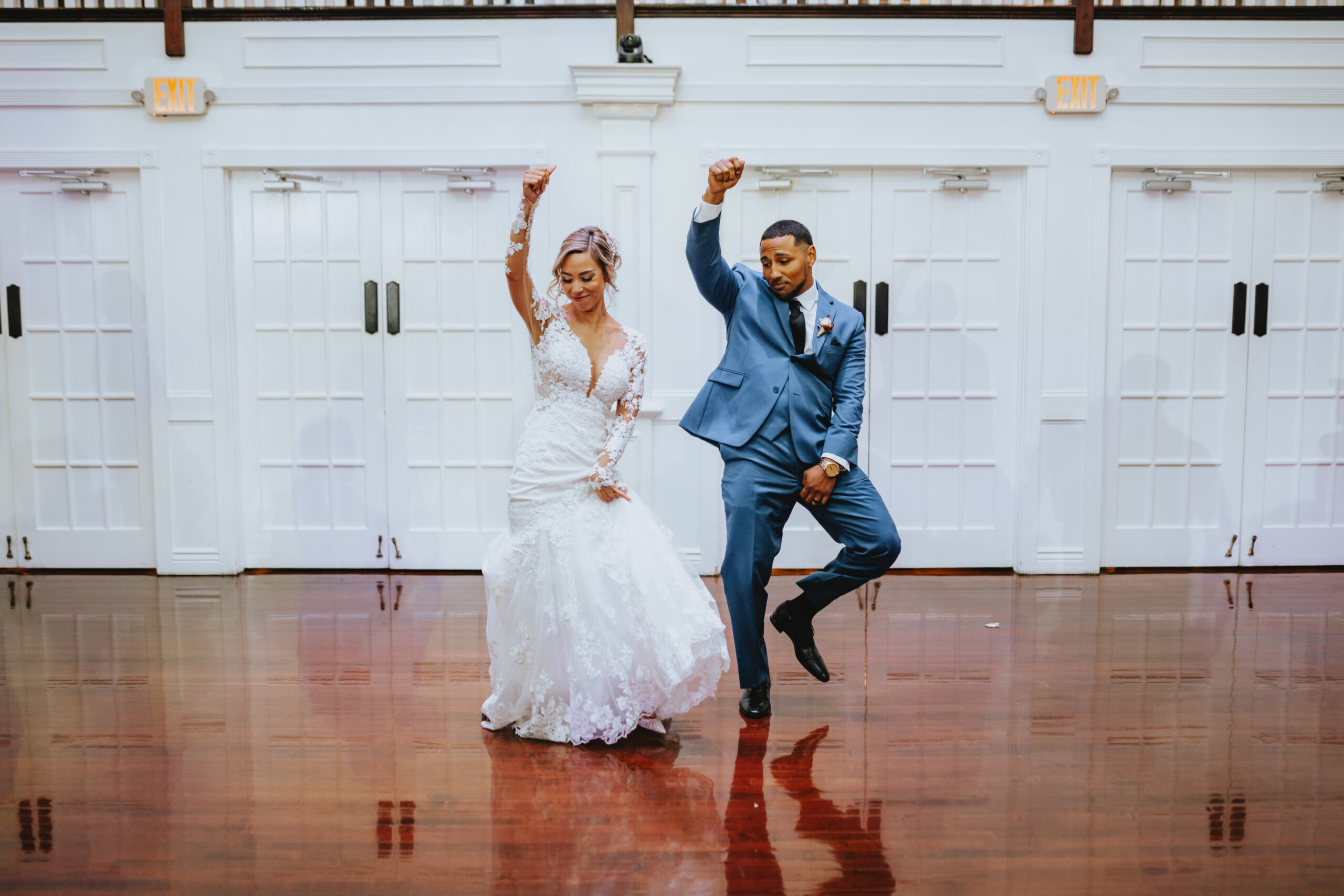 The bride and groom shuffle into reception during their entrain dance with one hand in the air at Hamilton Manor.