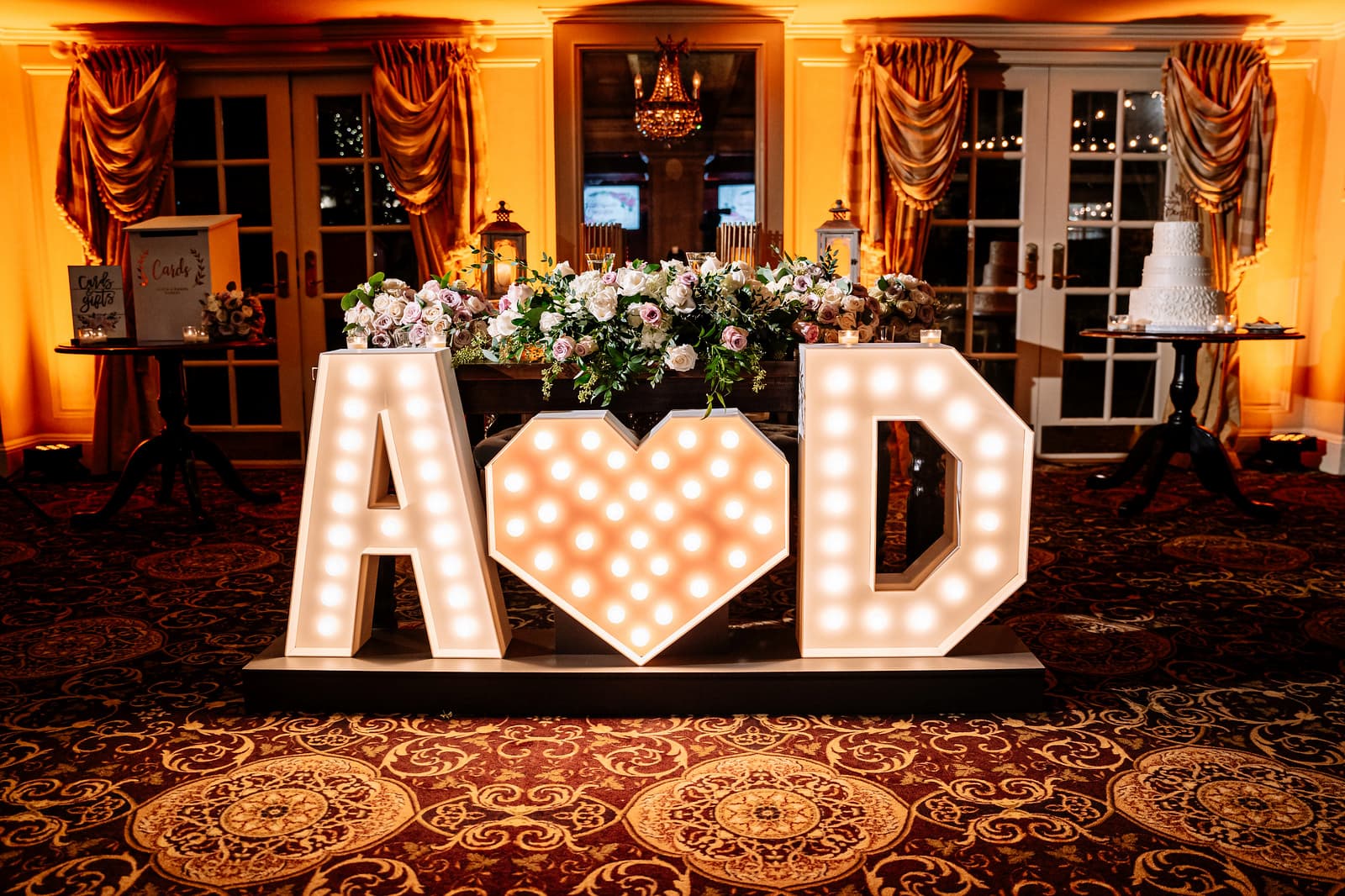 A huge light up wooden sign has an uppercase A, a heart and an uppercase D, for the couple's initials.