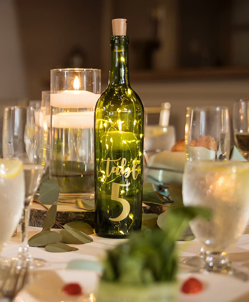 Wine bottles were used as table numbers and centerpieces at this wedding at Blue Heron Pines Golf Club.