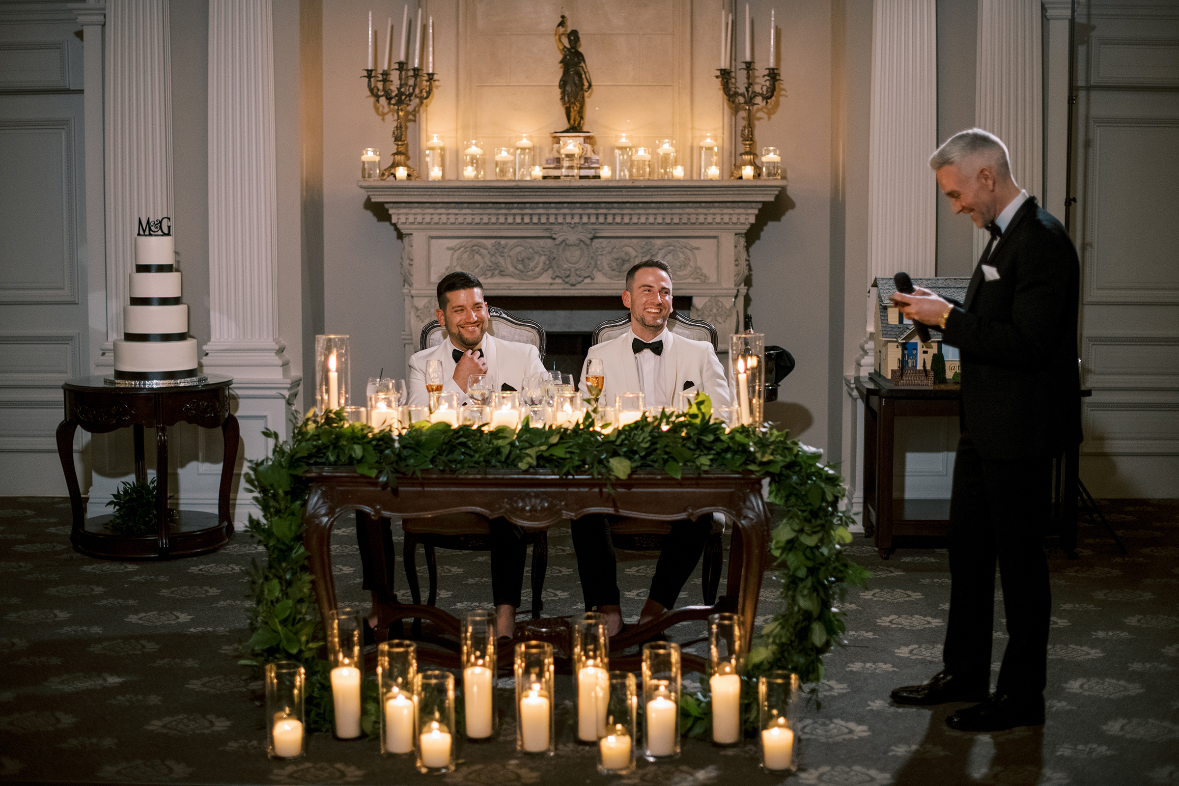 The grooms at their grooms table for two with greenery and many candles at their Park Savoy Estate wedding.