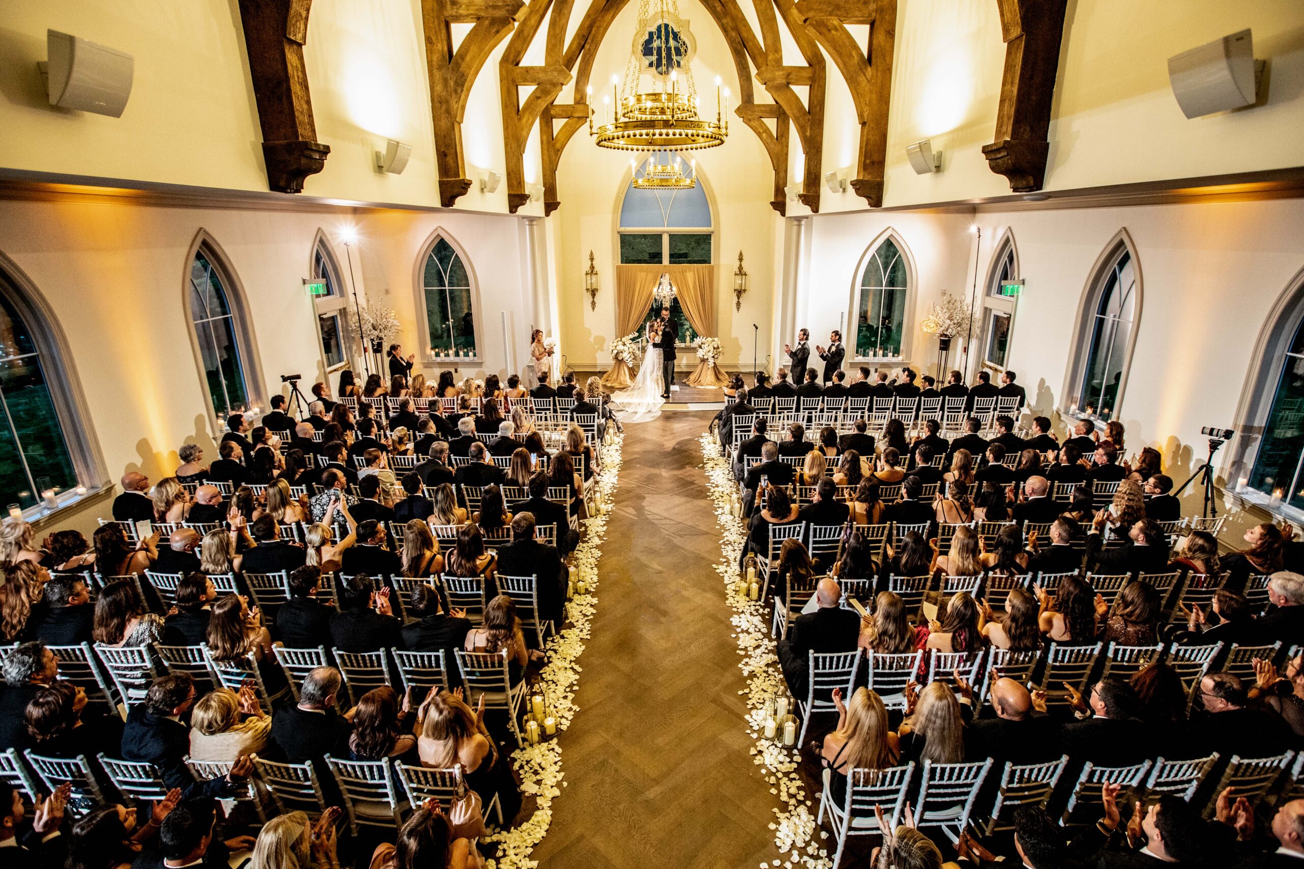 A birds eye view of the inside of the chapel at the Park Chateau during a packed ceremony with the bride and groom at the altar.