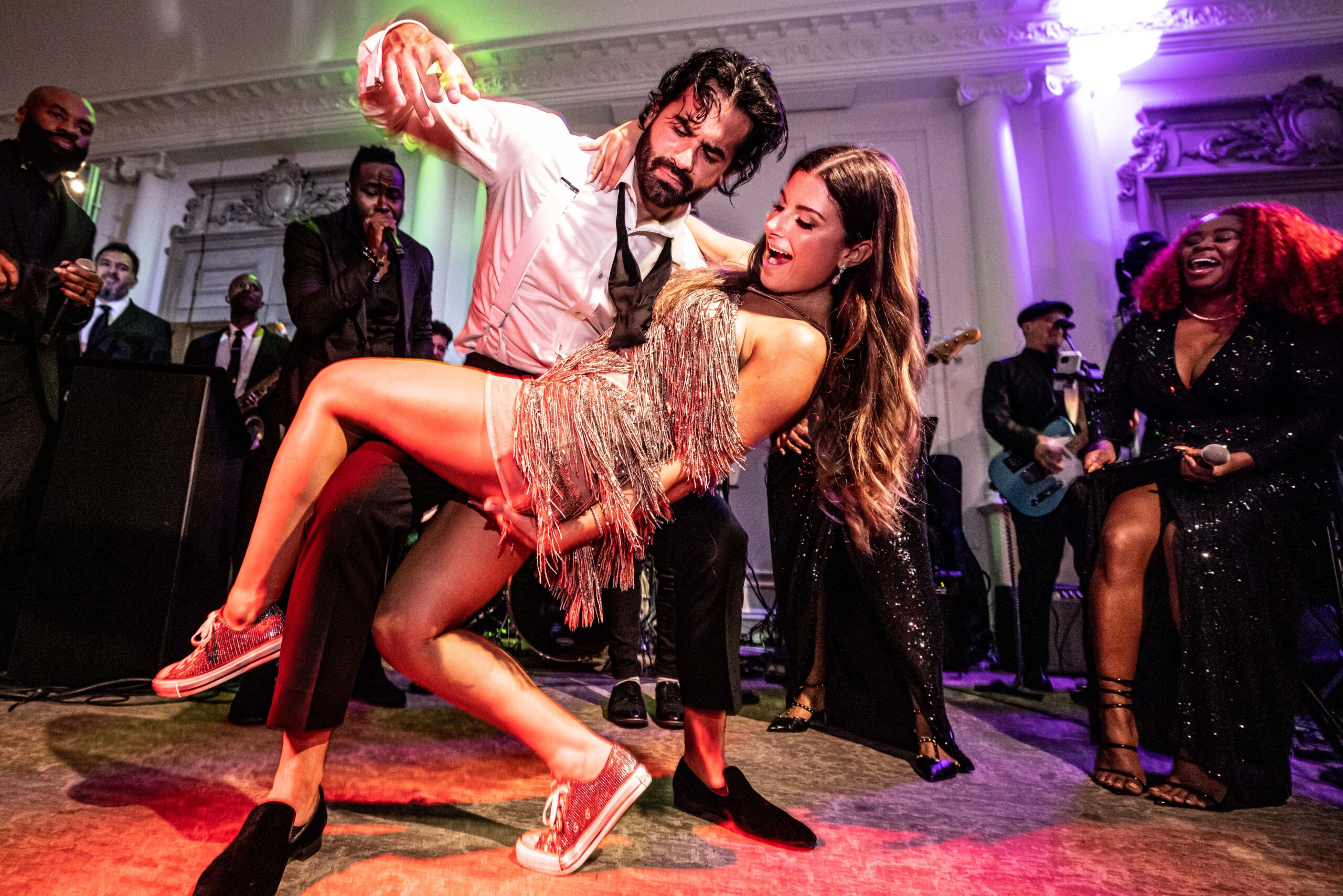 The bride and groom get down on the danceloor. The bride dons sparkly sneakers and a short fringe dress at this Park Chateau wedding.