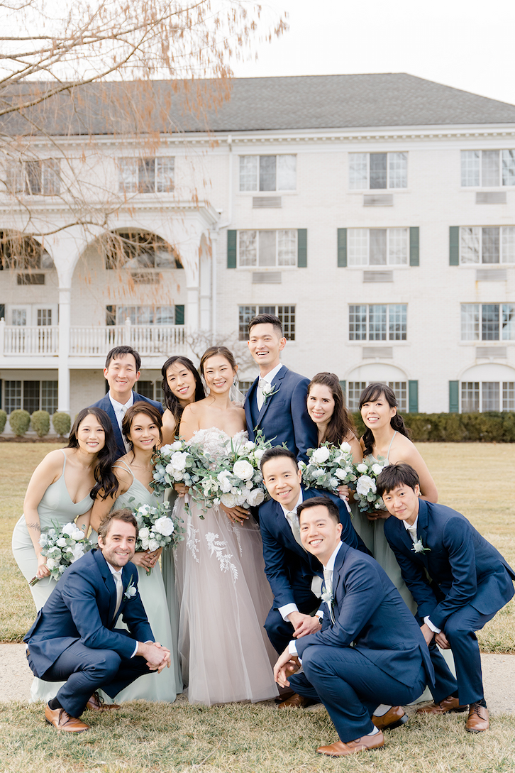 The bride and groom huddled with their wedding party outside the Madison Hotel.