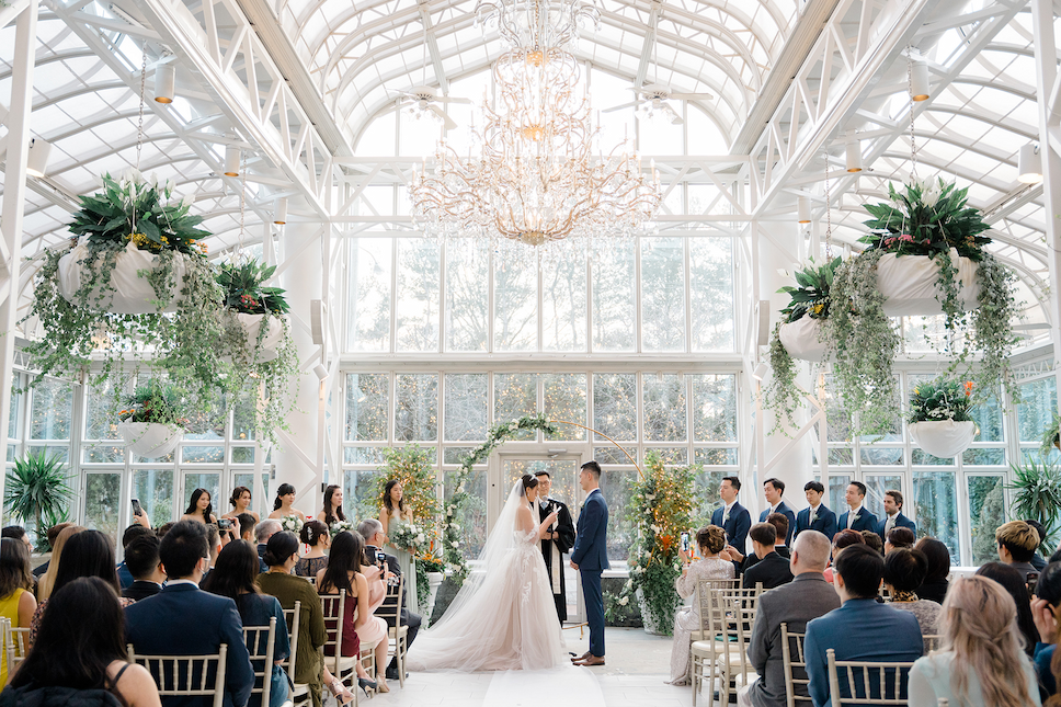 The bride and groom exchange vows in the all-glass room at their Madison Hotel wedding.