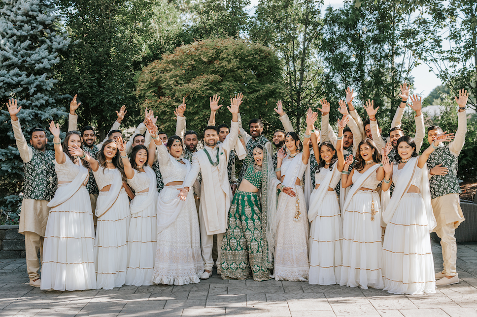 The bride and groom are flanked by their large wedding party outdoors at the Westmount Country Club.